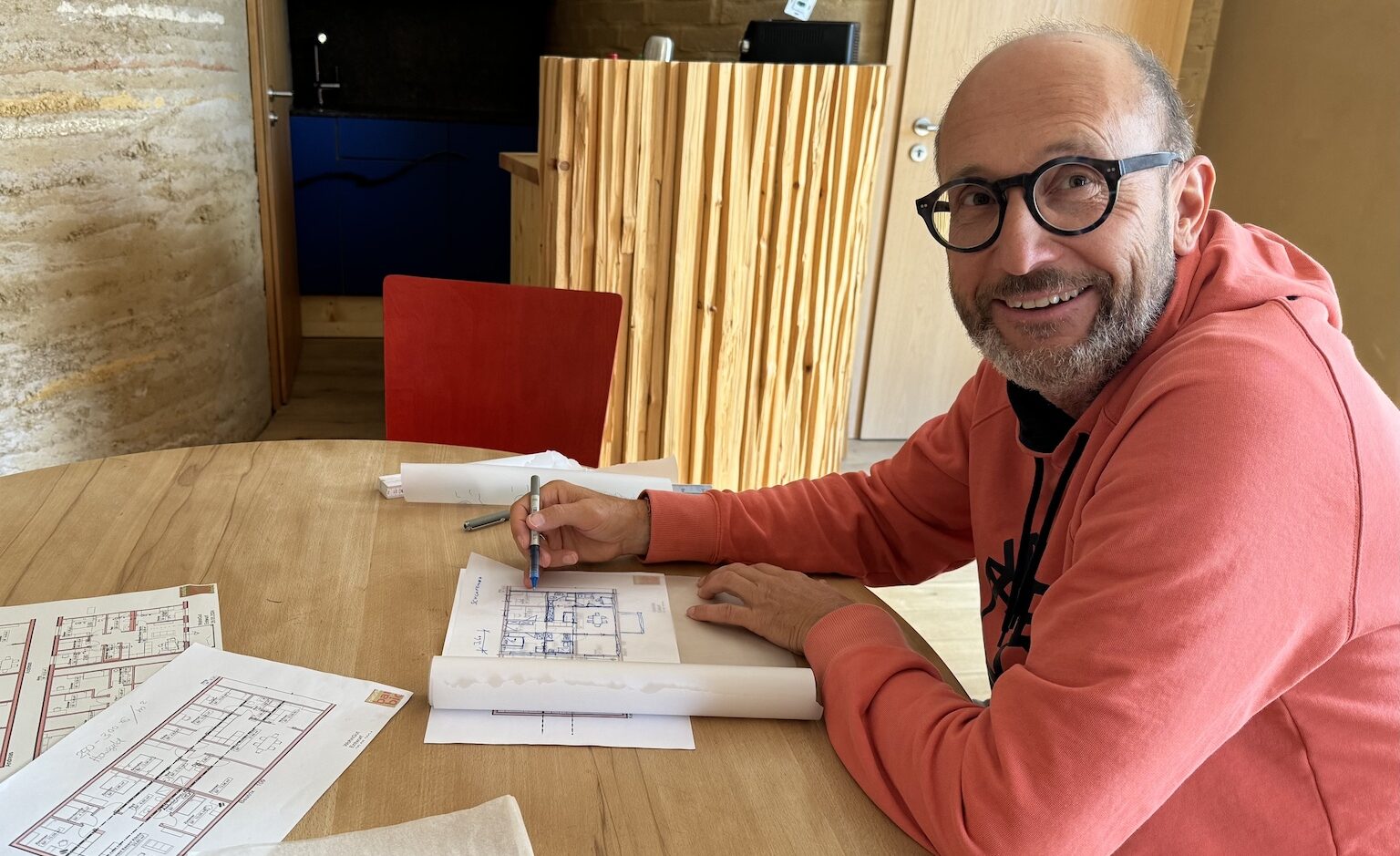 Unser Architekt Uli Bauer sitzt am Tisch in seinem Büro und arbeitet am Plan für eine Wohnung