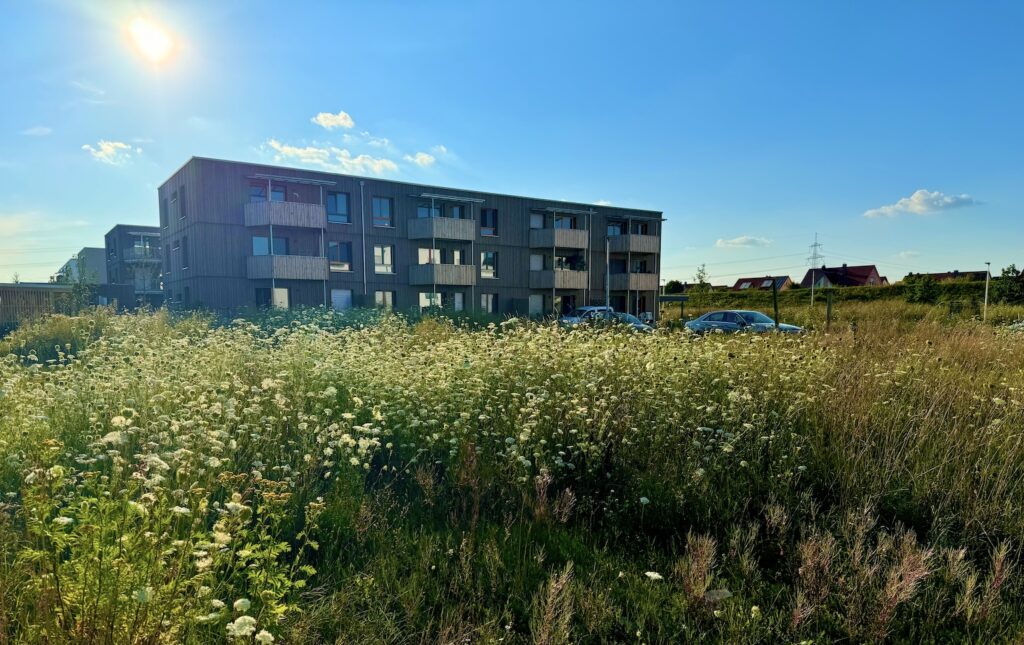 Im Vordergrund befindet sich das Bauland. Im Hintergrund ist das benachbarte Gemeinschaftsprojekt 'Raumteiler' zu sehen.